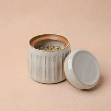 This small lidded jar in Linen glaze has a quiet, understated beauty. The glaze settles into a soft, pale gray with a slightly warm undertone, and where it thins over the carved vertical lines that encircle the body, the warm, sandy brown clay peeks - Saved to Pinterest (pinterest.com/alex) This small lidded jar in Linen glaze has a quiet, understated beauty. The glaze settles into a soft, pale gray with a slightly warm undertone, and where it thins over the carved vertical lines that encircle the body, the warm, sandy brown clay peeks